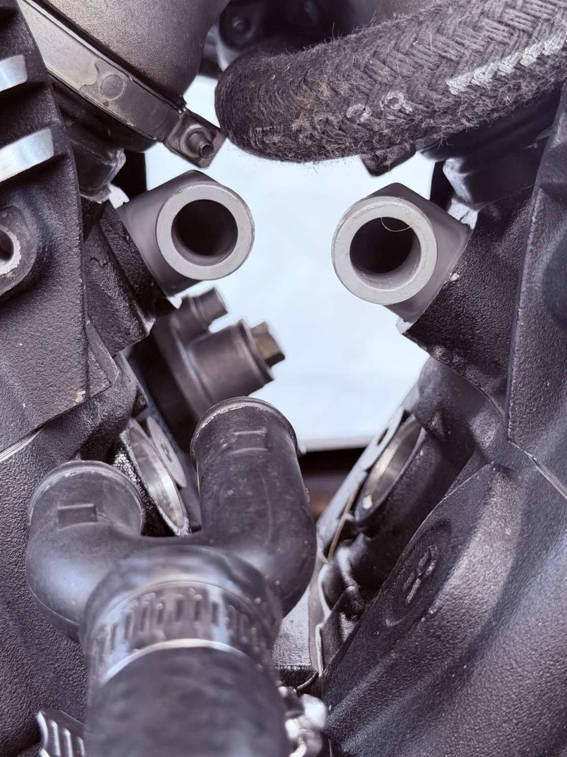 Pair of coolant sleeve elbow connections installed between the motorcycle engine cylinders
